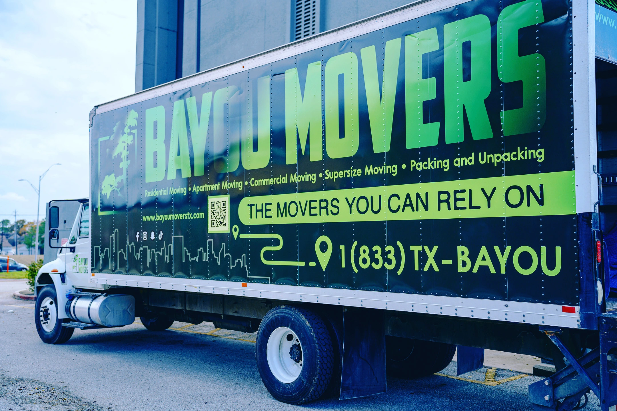 Side view of a branded Bayou Movers moving truck
