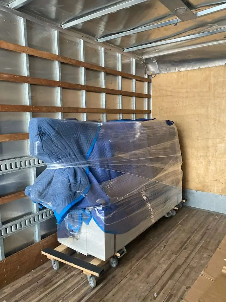 Bayou Movers heavy item moving with a wrapped item secured inside the truck